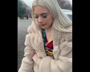 A nice blondie in colorfull dress is smoking and spitting