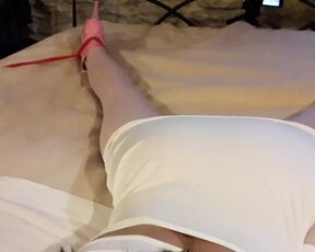 Laura is wearing a sexy white dress, pink pantyhose and platform heels, tied up and gagged in a bed