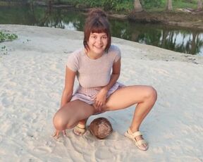 A shy girl squirts a small trickle of pee on a coconut